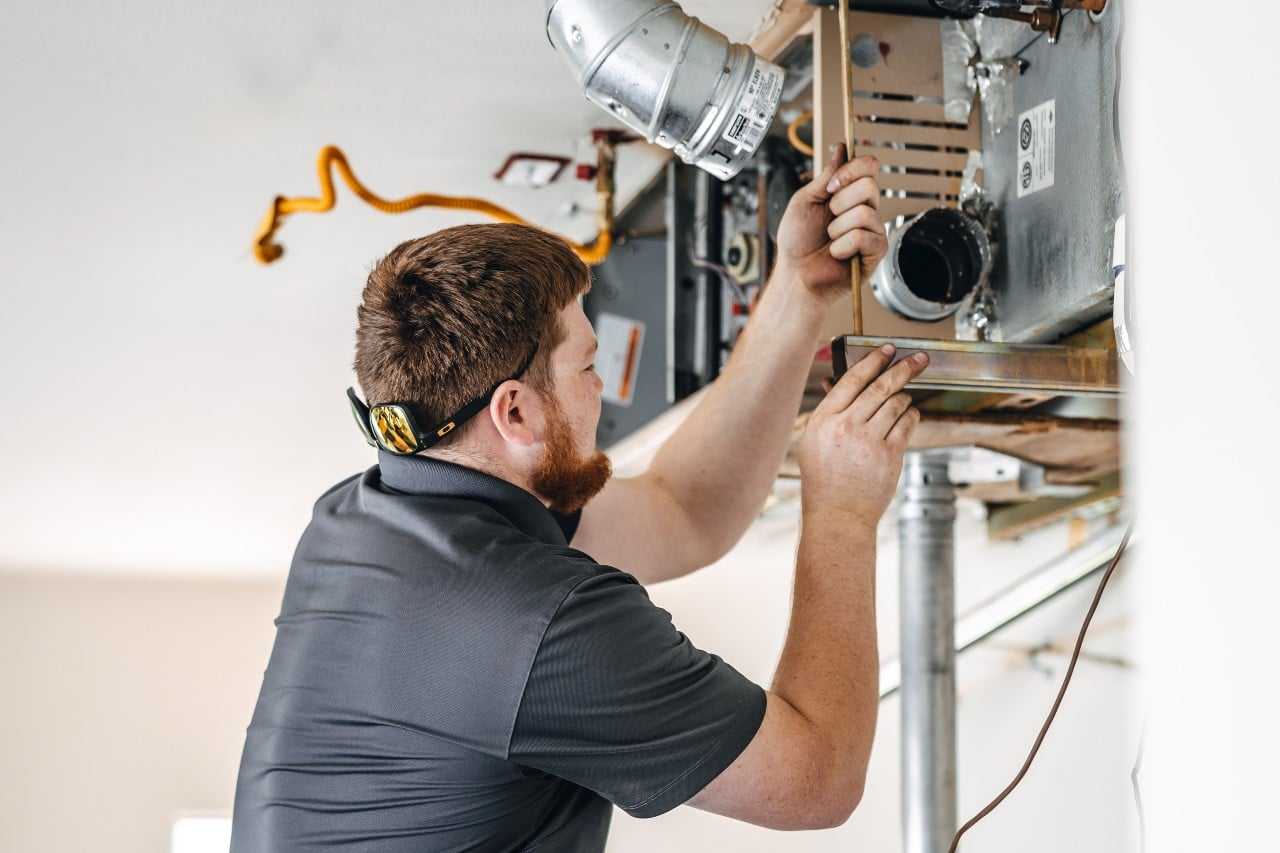 man doing regular furnace maintenance and tune-ups Apollo Heating and Air